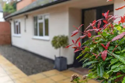 a house with red plants in front of it at Branlea - In the Heart of Ludlow in Ludlow