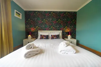 a bedroom with a bed with towels on it at Parc Y Deri in Aberystwyth