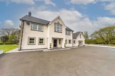 a large white house with a driveway at Parc Y Deri in Aberystwyth