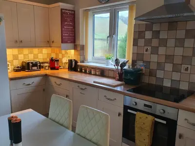 a kitchen with a table and a stove and a window at Idyllic 2 Bedroom Self-Contained UpsideDown Annexe in Llandrindod Wells