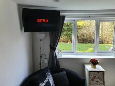 a television hanging in a room with a window at Idyllic 2 Bedroom Self-Contained UpsideDown Annexe in Llandrindod Wells