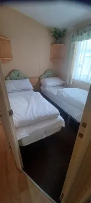 two bunk beds in a room with a window at Caravan 76 snowdon summit 016 in Talybont