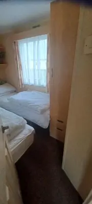 a hotel room with two beds and a window at Caravan 76 snowdon summit 016 in Talybont