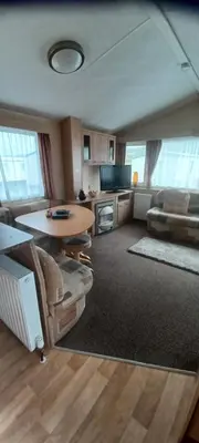 a living room with a table and a couch at Caravan 76 snowdon summit 016 in Talybont