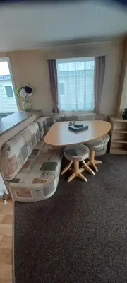 a living room with a table and a couch at Caravan 76 snowdon summit 016 in Talybont