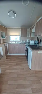 a kitchen with wooden cabinets and a counter top at Caravan 76 snowdon summit 016 in Talybont
