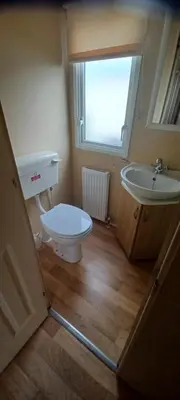 a bathroom with a toilet and a sink at Caravan 76 snowdon summit 016 in Talybont
