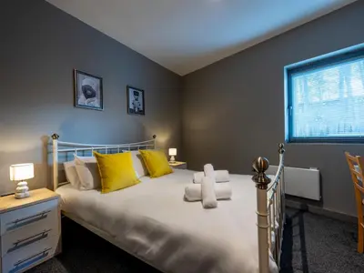 a bedroom with a bed with yellow pillows and a window at Modern flat a short walk from Shrewsbury centre - Pass the Keys in Shrewsbury