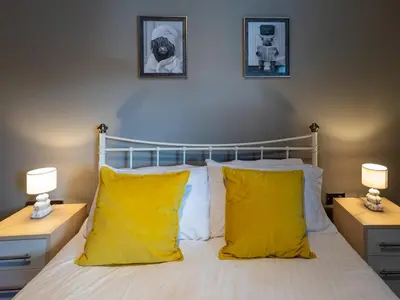 a bedroom with a bed with yellow pillows and two lamps at Modern flat a short walk from Shrewsbury centre - Pass the Keys in Shrewsbury
