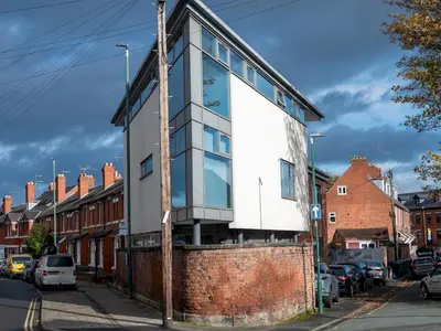 a house on a brick wall on a street at Modern flat a short walk from Shrewsbury centre - Pass the Keys in Shrewsbury