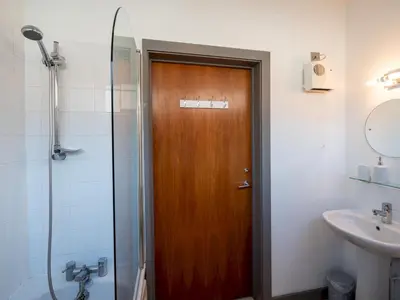 a bathroom with a wooden door and a sink at Modern flat a short walk from Shrewsbury centre - Pass the Keys in Shrewsbury