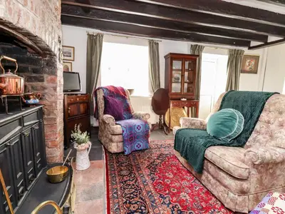a living room with two chairs and a fireplace at Wharf Cottage in Llangollen