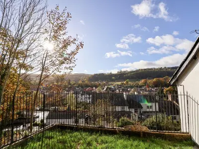 a view from the backyard of a house with a fence at Wharf Cottage in Llangollen
