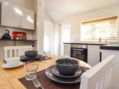 a kitchen with a wooden table with bowls on it at Tan Isa in Harlech