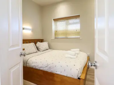 a small bedroom with a bed and a window at Tan Isa in Harlech