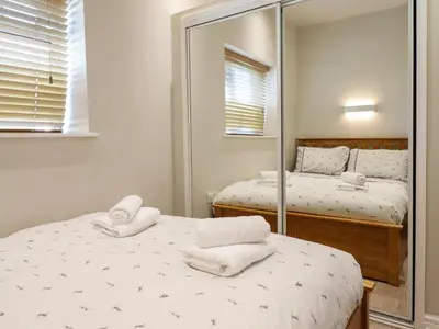 a bedroom with two beds and a mirror at Tan Isa in Harlech
