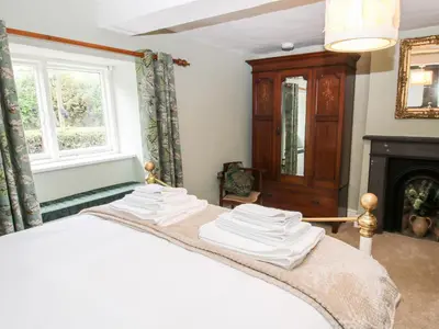 a bedroom with a bed and a fireplace at Pentre Hall in Oswestry