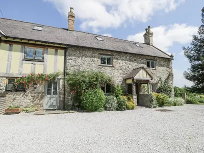 an old stone house with a driveway at Pentre Hall in Oswestry