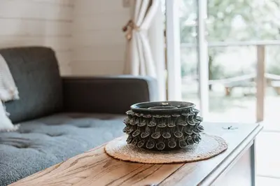 a vase sitting on a table next to a couch at Secluded Cosy Luxury Pod with wood fired hot tub in Shrewsbury
