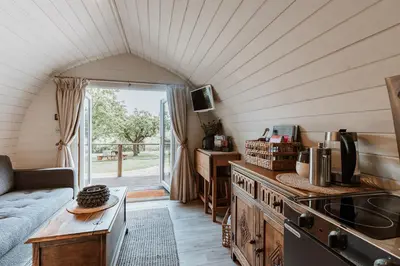 a kitchen with a couch and a table in a room at Secluded Cosy Luxury Pod with wood fired hot tub in Shrewsbury