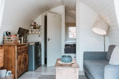 a living room with a couch and a table at Secluded Cosy Luxury Pod with wood fired hot tub in Shrewsbury