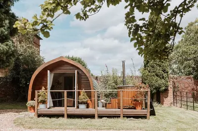 a small wooden iguana house in a garden at Secluded Cosy Luxury Pod with wood fired hot tub in Shrewsbury
