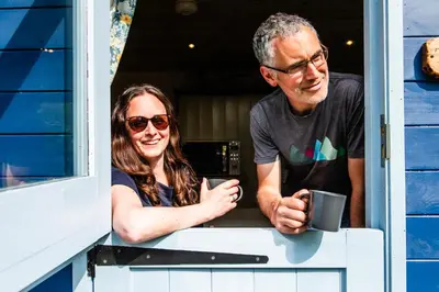 a man and a woman looking out of a window at Cosy Shepherd's Hut with Hot Tub in Church Stretton