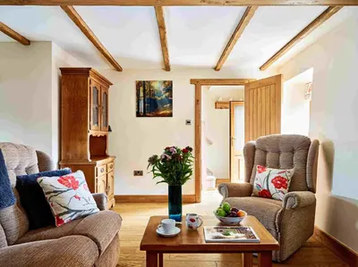 a living room with two chairs and a coffee table at Trefaen Cottage in Brecon