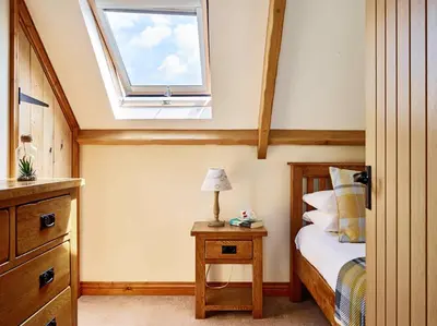 a bedroom with a bed with a window on the ceiling at Trefaen Cottage in Brecon