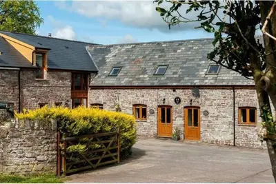 a brick building with orange doors and a fence at Trefaen Cottage in Brecon