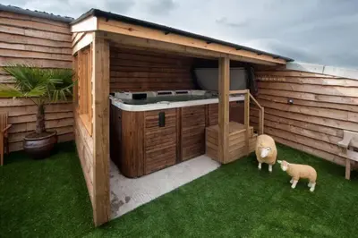 a outdoor kitchen with a sheep standing in the grass at Oak Barn in Brecon