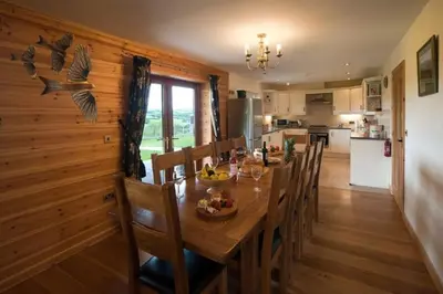 a kitchen and dining room with a table and chairs at Poplar Tree Eco Lodge in Brecon