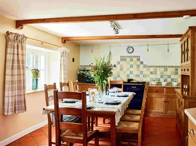 a dining room with a table and chairs in a kitchen at Onnen Fawr Farmhouse in Brecon