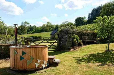 a wooden tub sitting in the grass in a yard at The Ash Cottage in Brecon