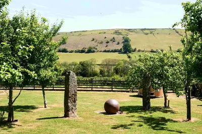 a sculpture in a field with trees and a fence at The Ash Cottage in Brecon