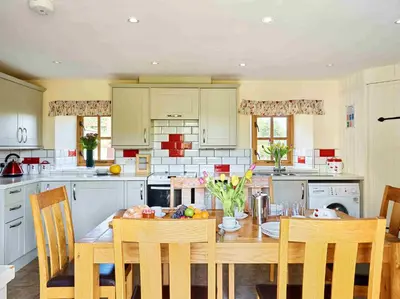 a kitchen with a wooden table and chairs at The Ash Cottage in Brecon