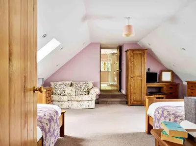 a attic bedroom with two beds and a couch at Sycamore Tree Barn in Brecon