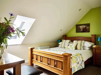 a bedroom with a bed and a green wall at Sycamore Tree Barn in Brecon