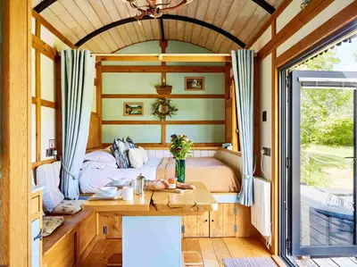 a bedroom in a tiny house with a bed at The Mallard Shepherd's Hut with Hot Tub in Brecon