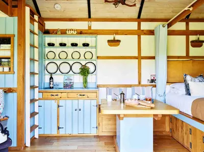 a kitchen with a bed and a table in a room at The Mallard Shepherd's Hut with Hot Tub in Brecon
