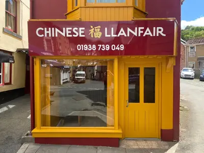 a building with a yellow door on a street at Bryntirion Farmhouse Apartment with Hot Tub in Llanfair Caereinion