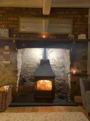 a fireplace in a room with a brick wall at Ty Twty, Montgomery Cottage in Montgomery