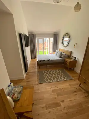 a bedroom with a bed and a wooden floor at Dave & Kelz Deluxe king size studio room in Builth Wells