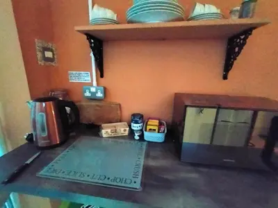 a kitchen counter with a coffee maker and a microwave at Yr Hen Efail - Quirky Old Smithy cottage near forest walks, cycling & lakes in Garthbeibio