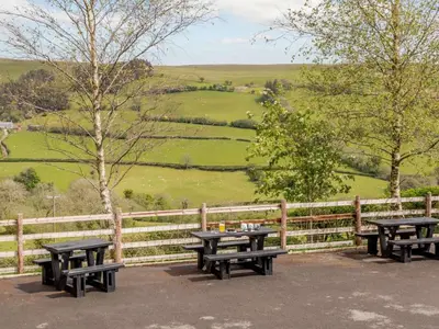 a group of picnic tables in front of a fence at 2 Bed in Brecon oc-bn310 in Cray