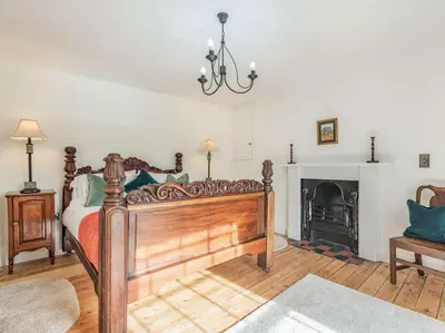a bedroom with a wooden bed and a fireplace at 3 Bed in Corwen oc-86266 in Corwen
