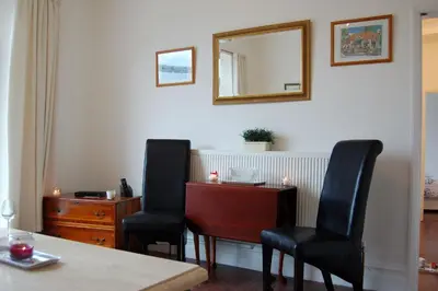 a room with two chairs and a table and a mirror at Beach Vista Apartment One in Barmouth in Barmouth