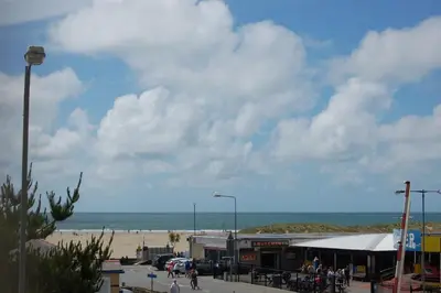 a group of people walking on a street near a beach at Beach Vista Apartment One in Barmouth in Barmouth