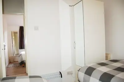 a bedroom with a white closet and a bed at Bryniau Gwyrdd Chalet 11 Happy Valley in Tywyn