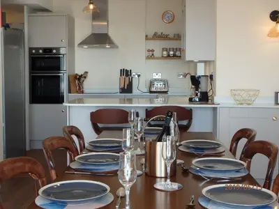 a kitchen with a table with plates and glasses on it at Bryn Mair in Barmouth in Barmouth